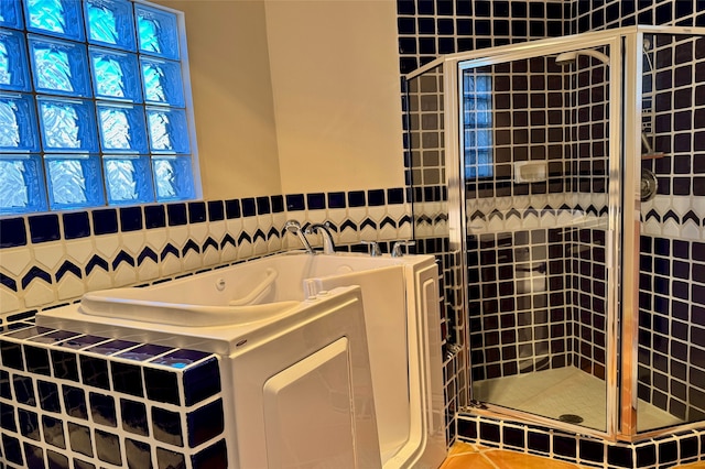 bathroom featuring a shower stall, a bath, and tile patterned floors