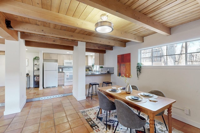 dining room featuring beamed ceiling, light tile patterned flooring, wood ceiling, and baseboards