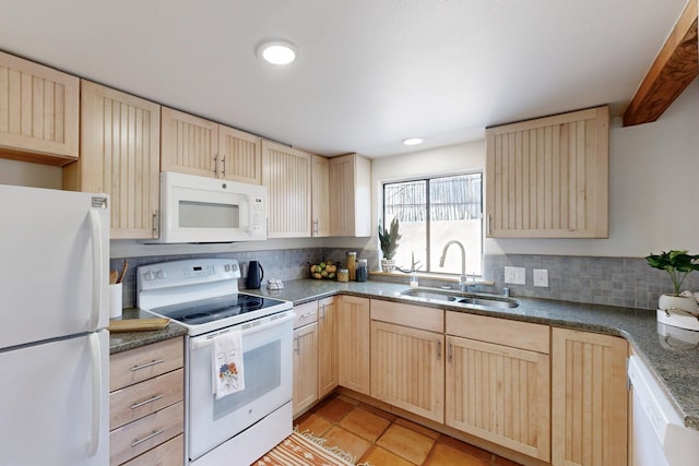 kitchen featuring dark countertops, white appliances, decorative backsplash, and a sink