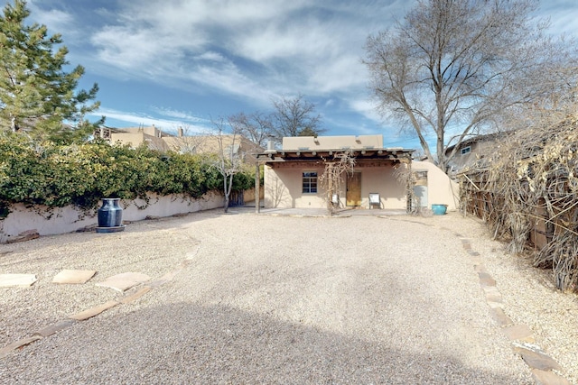 view of front of home featuring a fenced backyard and stucco siding