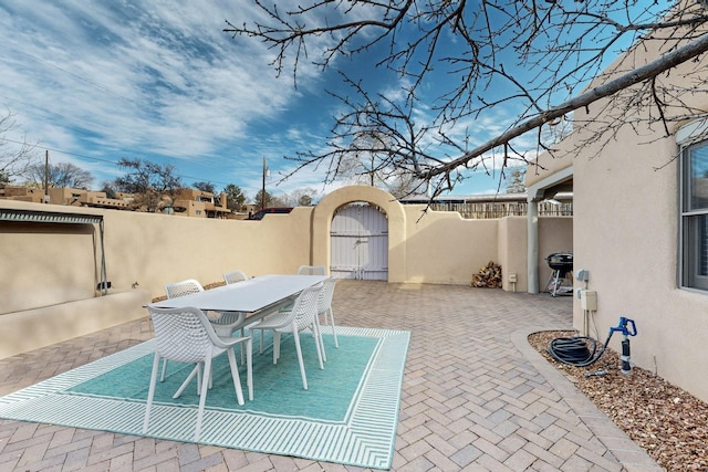 view of patio / terrace with outdoor dining space, a fenced backyard, and a gate