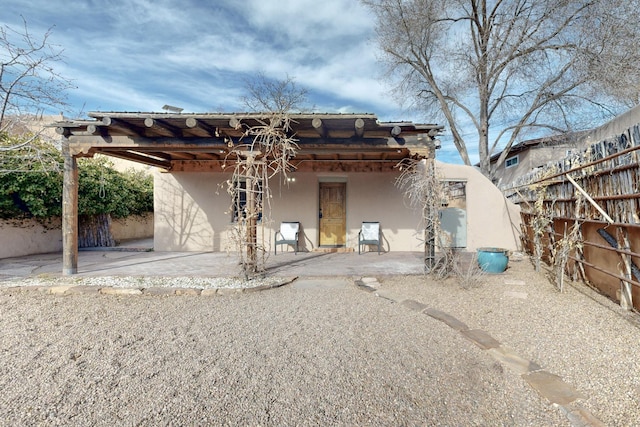 back of house with a fenced backyard, a patio, and stucco siding