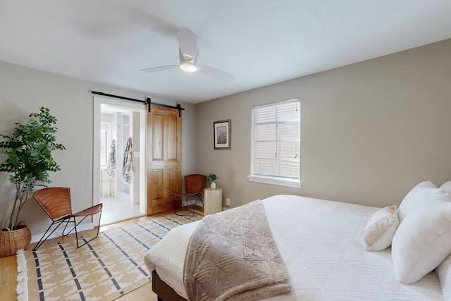 bedroom with a barn door and a ceiling fan