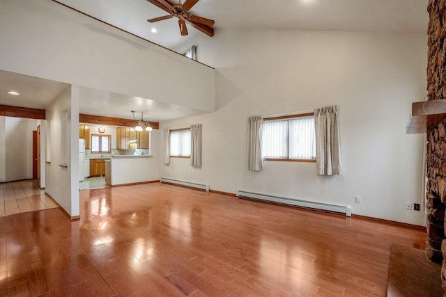 unfurnished living room featuring ceiling fan with notable chandelier, light wood finished floors, a baseboard radiator, and baseboards