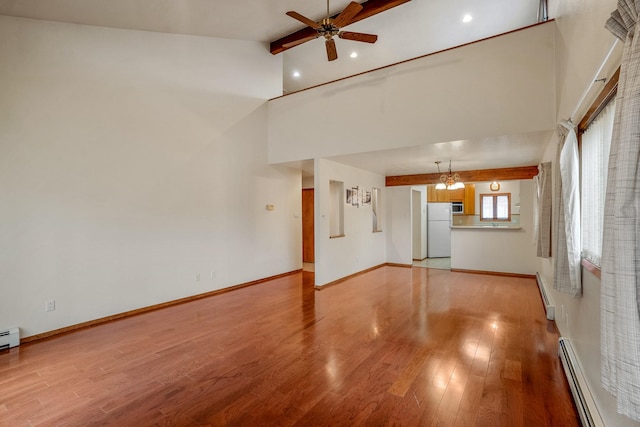 unfurnished living room featuring ceiling fan with notable chandelier, a baseboard radiator, baseboards, and wood finished floors