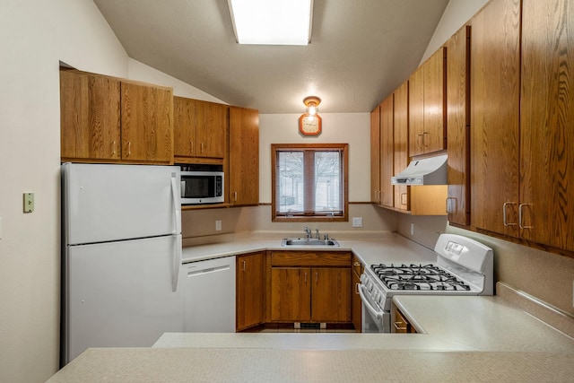 kitchen featuring white appliances, brown cabinetry, light countertops, under cabinet range hood, and a sink