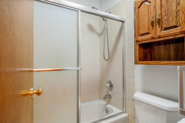 full bath featuring combined bath / shower with glass door and toilet