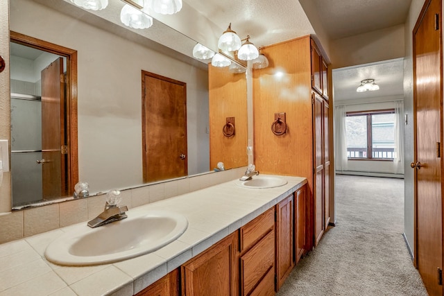 bathroom with a sink, baseboard heating, and double vanity