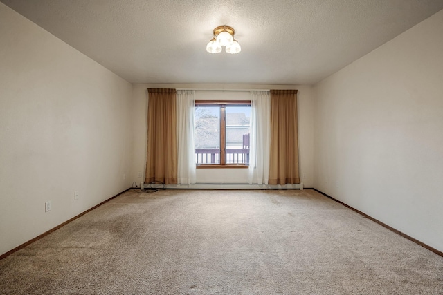 empty room with a textured ceiling, carpet floors, and baseboards