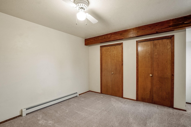 unfurnished bedroom featuring baseboards, baseboard heating, a textured ceiling, and light colored carpet