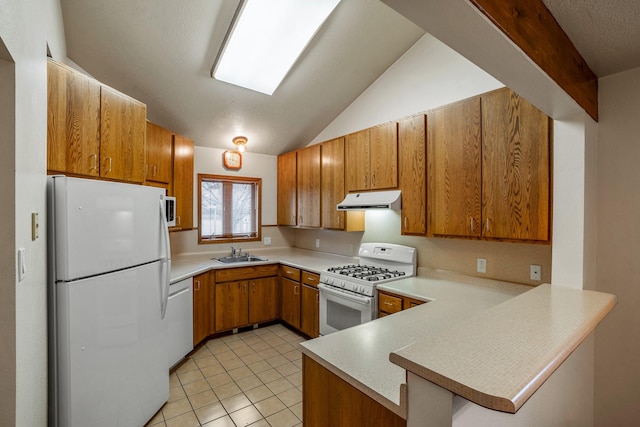 kitchen with a peninsula, white appliances, light countertops, and brown cabinetry