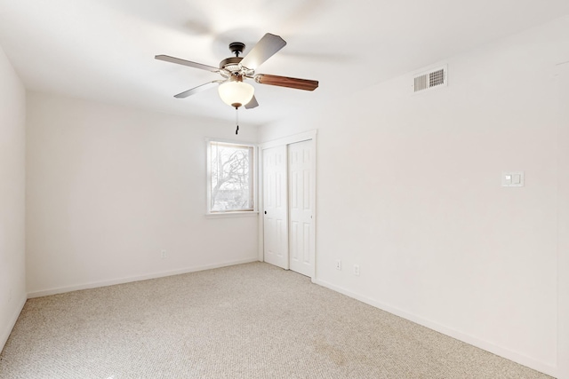 unfurnished room with carpet, visible vents, ceiling fan, and baseboards