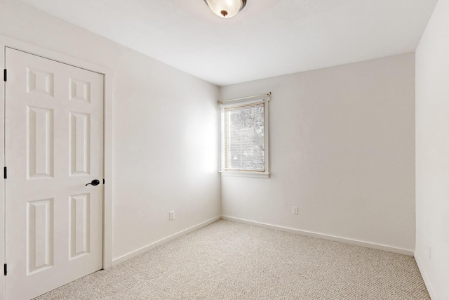 spare room with light colored carpet and baseboards