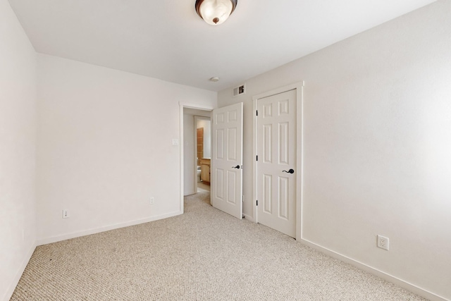 unfurnished bedroom with light carpet, baseboards, and visible vents