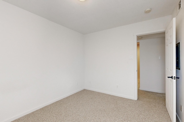 spare room with light carpet, visible vents, and baseboards