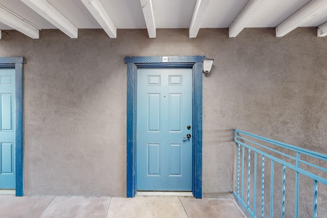 property entrance with stucco siding