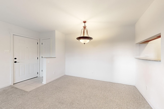 spare room featuring baseboards and light colored carpet