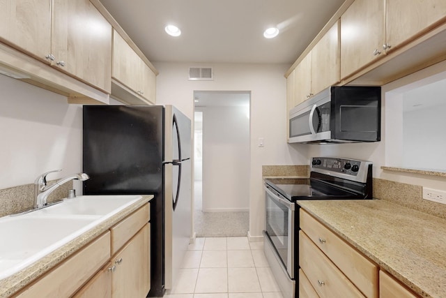 kitchen with visible vents, appliances with stainless steel finishes, light brown cabinets, a sink, and light tile patterned flooring