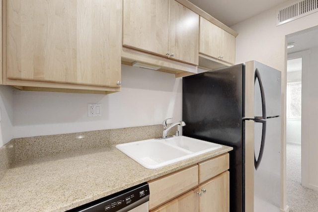 kitchen with stainless steel appliances, visible vents, a sink, and light brown cabinetry