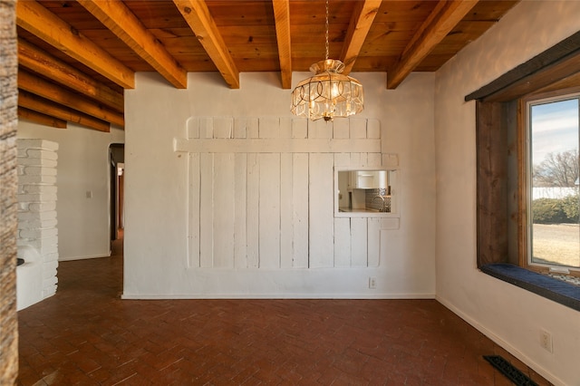 spare room featuring brick floor, a notable chandelier, wooden ceiling, beamed ceiling, and baseboards