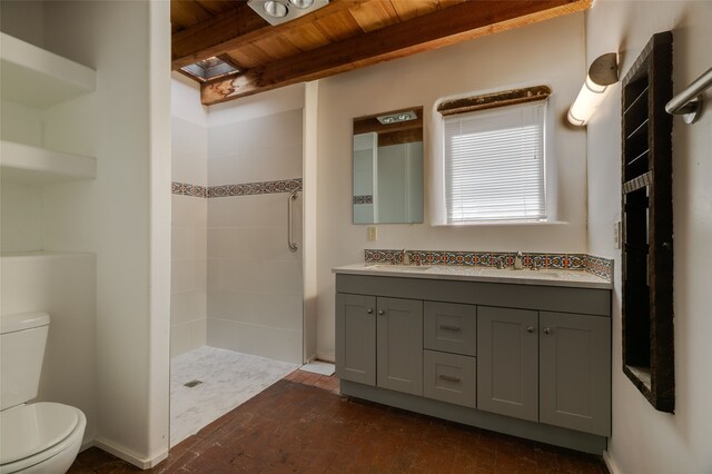 full bathroom featuring toilet, beam ceiling, a tile shower, and a sink