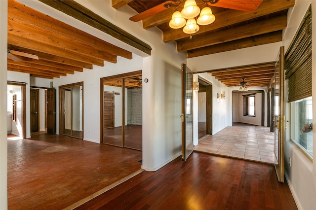 interior space featuring beamed ceiling, wood finished floors, and baseboards