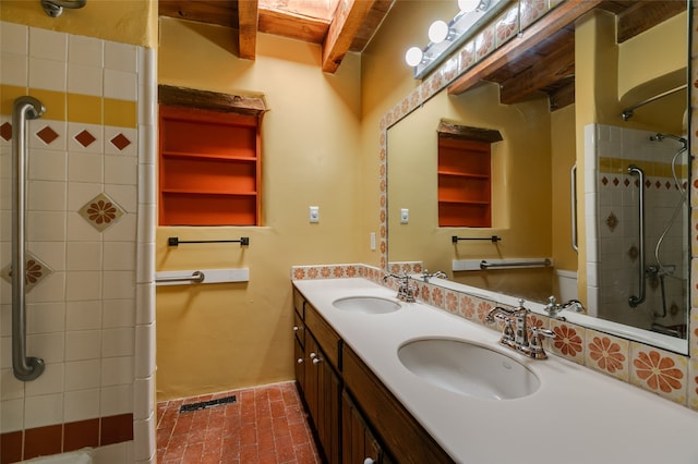 full bathroom with brick floor, a sink, a tile shower, and double vanity