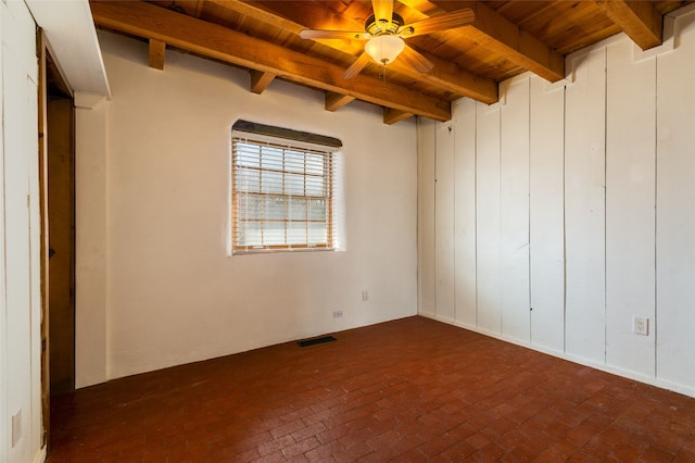 unfurnished room featuring brick floor, wooden ceiling, and beam ceiling