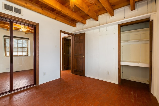 unfurnished bedroom with wood ceiling, beam ceiling, brick floor, and visible vents