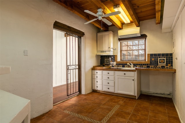 kitchen featuring wood ceiling, white cabinets, backsplash, beamed ceiling, and a wall mounted air conditioner