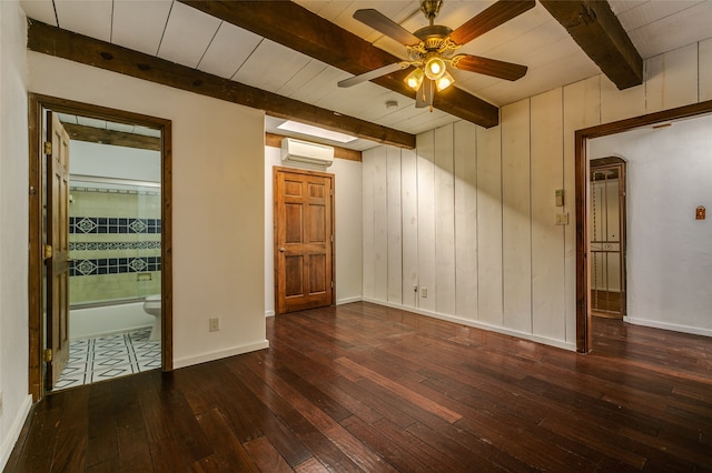 unfurnished room featuring beam ceiling, dark wood finished floors, ceiling fan, a wall mounted air conditioner, and baseboards