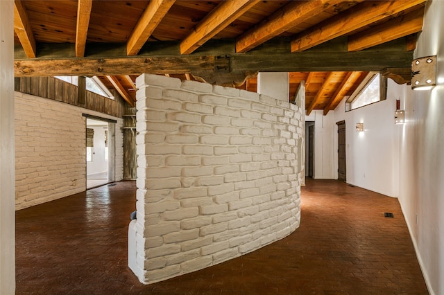 hall with brick floor, wooden ceiling, visible vents, and vaulted ceiling with beams