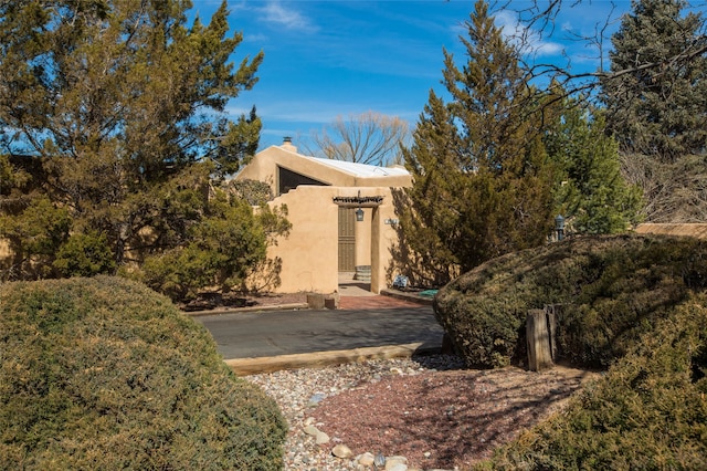 view of side of home featuring a chimney and stucco siding