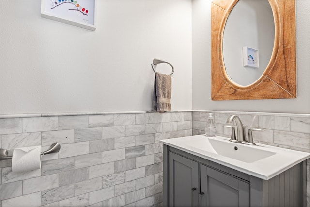 bathroom with a wainscoted wall, vanity, and tile walls