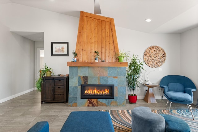 living room with recessed lighting, a fireplace, lofted ceiling, and baseboards