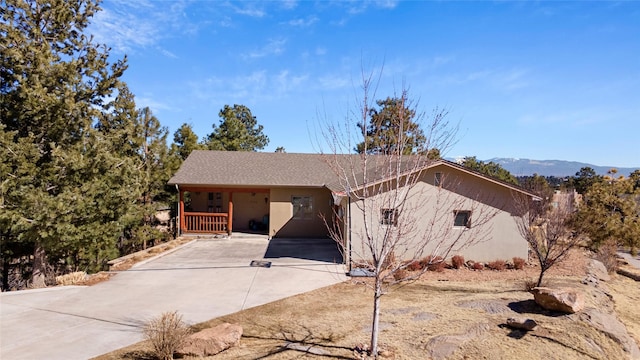 view of front of house featuring driveway, a mountain view, and stucco siding