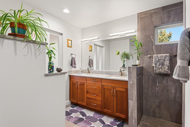 bathroom featuring double vanity, walk in shower, a sink, and recessed lighting