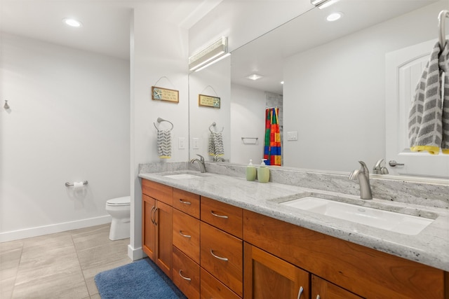 full bathroom with double vanity, toilet, a sink, and tile patterned floors