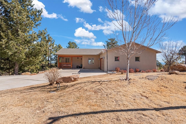 ranch-style house featuring concrete driveway and stucco siding