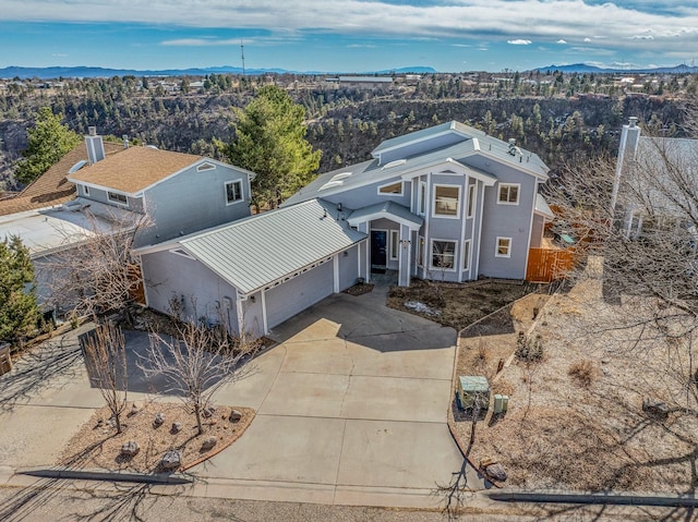 view of front facade with driveway, an attached garage, and a mountain view