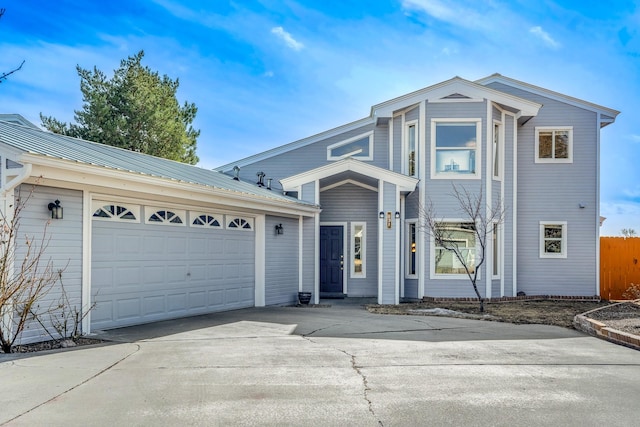 view of front of home featuring metal roof, driveway, and an attached garage