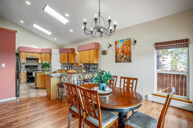 dining space featuring light wood-style floors, a chandelier, baseboard heating, and high vaulted ceiling