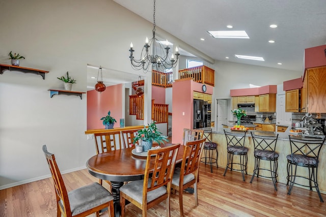 dining room with a chandelier, high vaulted ceiling, recessed lighting, baseboards, and light wood-type flooring