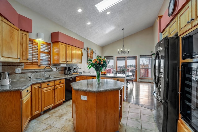 kitchen featuring pendant lighting, a notable chandelier, a sink, a kitchen island, and black appliances