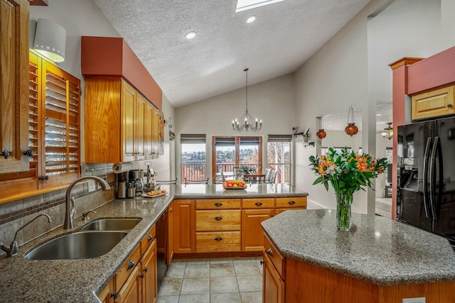 kitchen with lofted ceiling, a sink, a peninsula, and black appliances