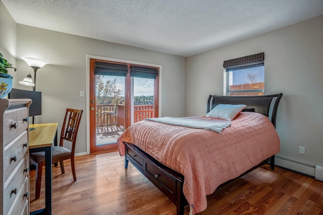 bedroom featuring baseboards, dark wood finished floors, access to exterior, baseboard heating, and a textured ceiling