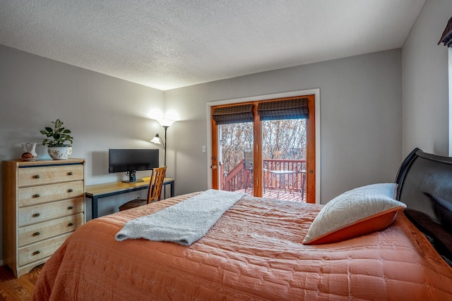 bedroom with access to exterior, a textured ceiling, and wood finished floors