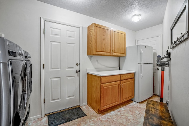 laundry area with washer / dryer, a textured ceiling, baseboards, and cabinet space