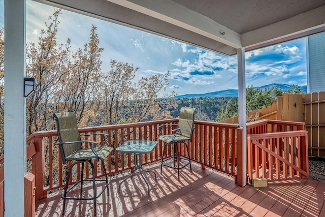 wooden deck with a mountain view and fence