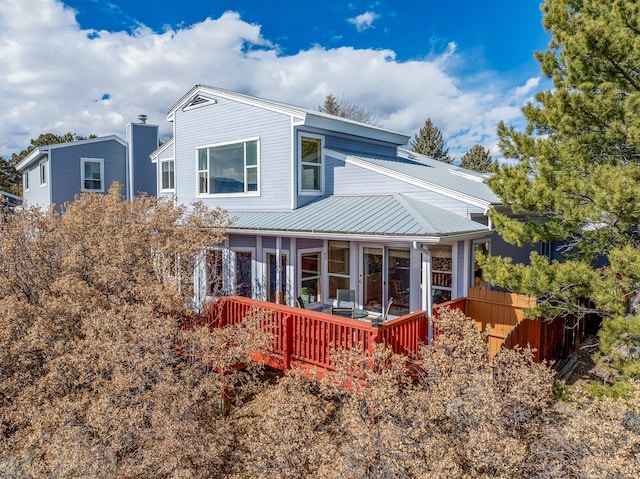 rear view of house featuring metal roof and a sunroom